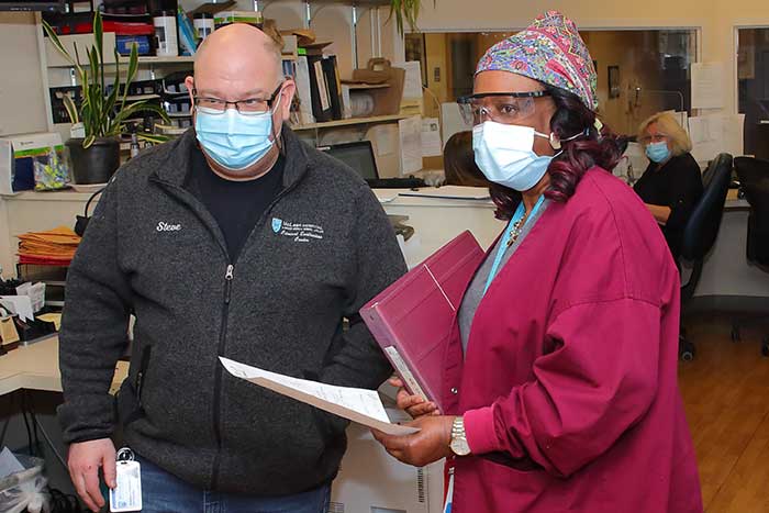 2 nurses discuss paperwork
