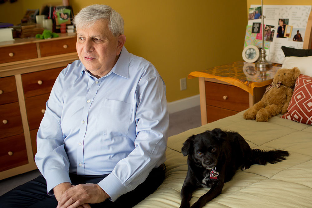 Man and dog sit on bed
