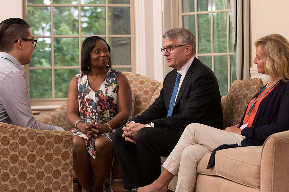 Patient and clinicians talk in living room