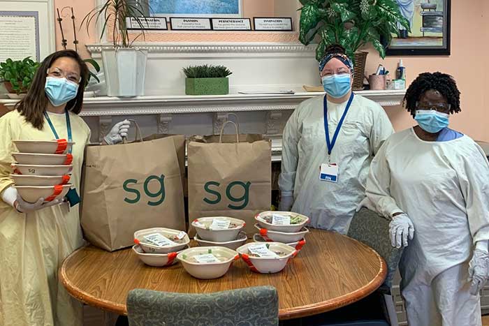 Staff in PPE with in-kind food donations