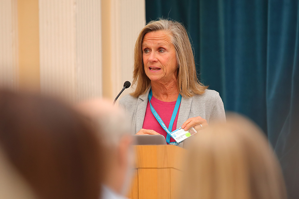 Paula Bolton speaks at a podium at McLean