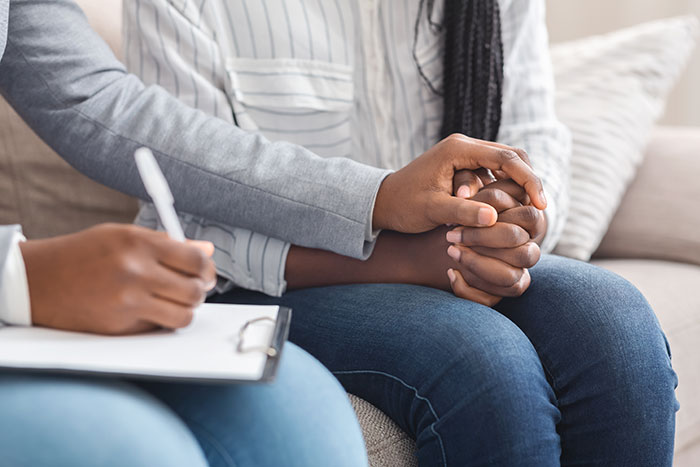 Therapist’s hand holds that of a patient