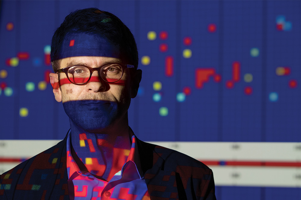 Justin T. Baker, MD, PhD, with graphs projected on and around him
