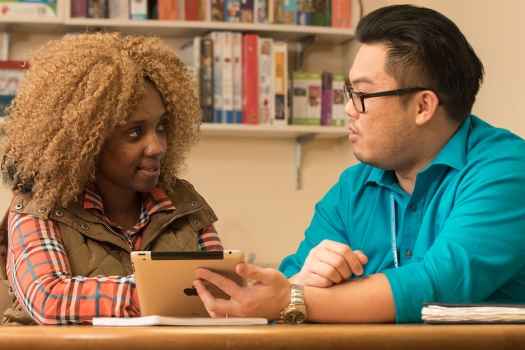 Patient and clinician talk, clinician shows tablet