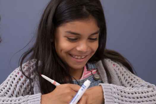 Two young kids color with markers