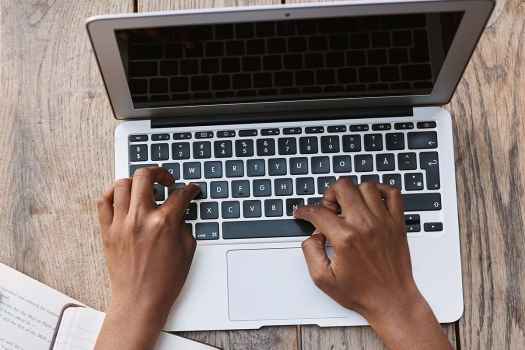 Hands typing on laptop