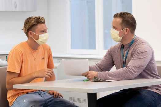 Staff talks to young patient sitting at table