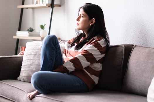Woman sits on couch