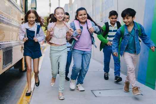 Children walking next to a school bus