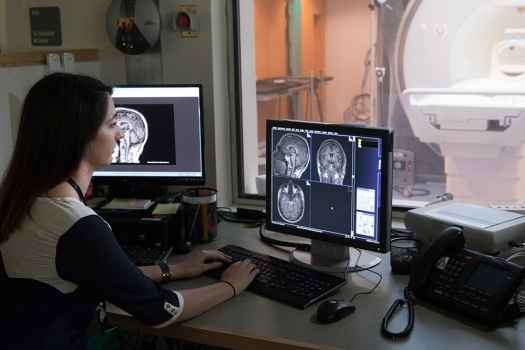 Woman looking at computer screen of brain scans