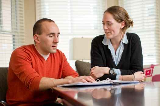 2 people sit at table talking