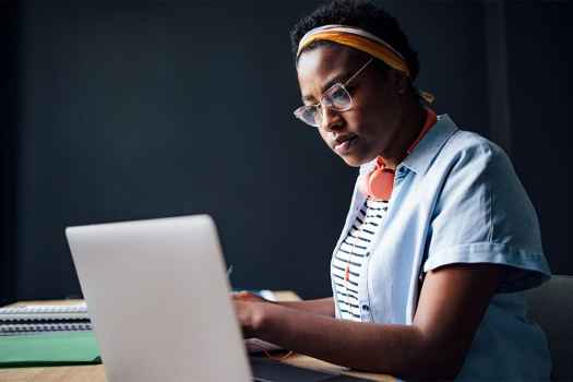 Young adult looks at laptop
