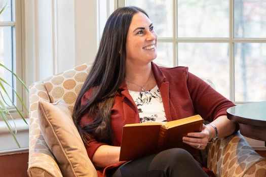 Person reads book in comfy chair