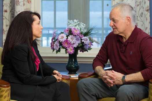 Clinician and older patient sit and talk