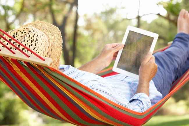Person reading ereader in hammock
