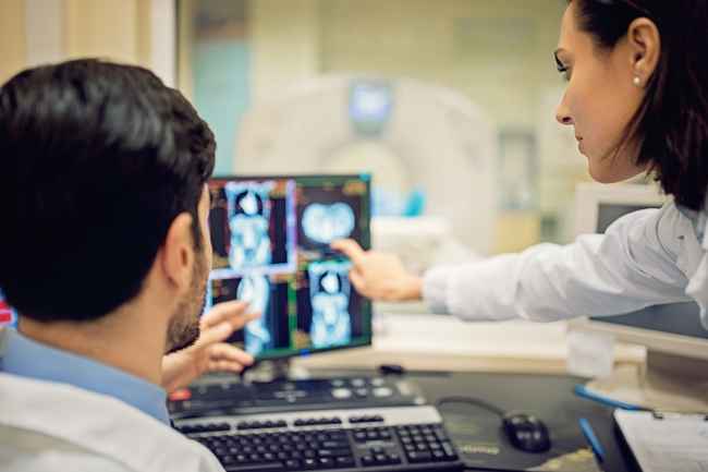 Researchers look at neuroimaging scans on computer screen