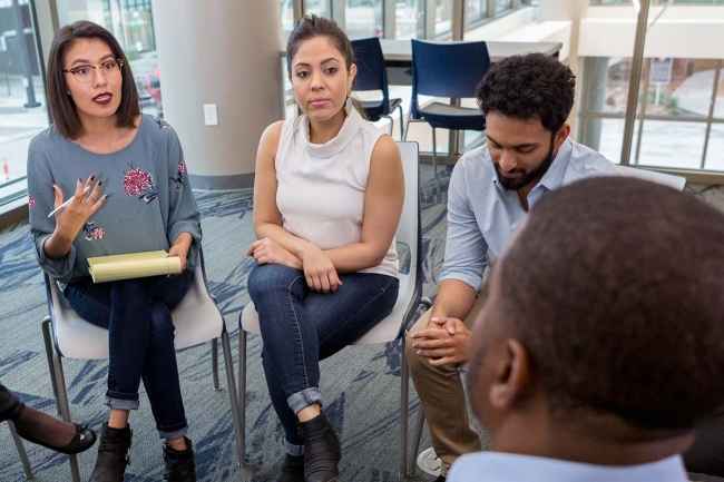 Clinician and patients in group therapy