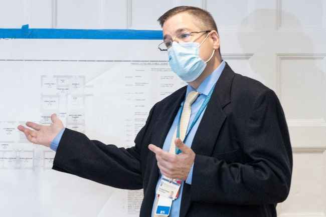 Man points at architectural drawings