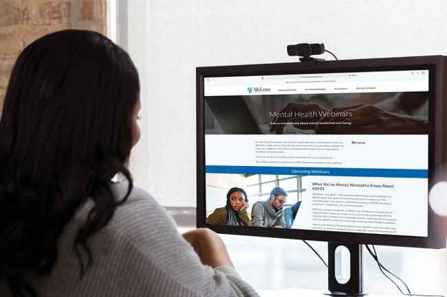 Woman looks at webpage on computer screen