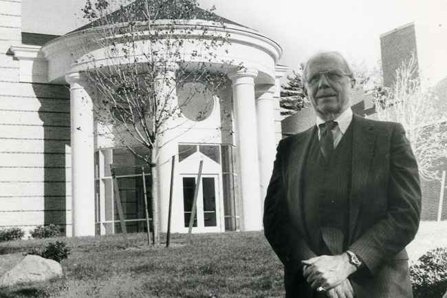 B&W photo of man in front of building