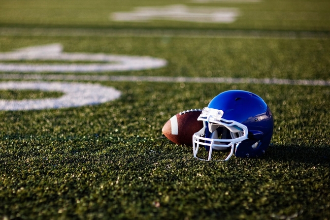 Blue helmet and football on football field