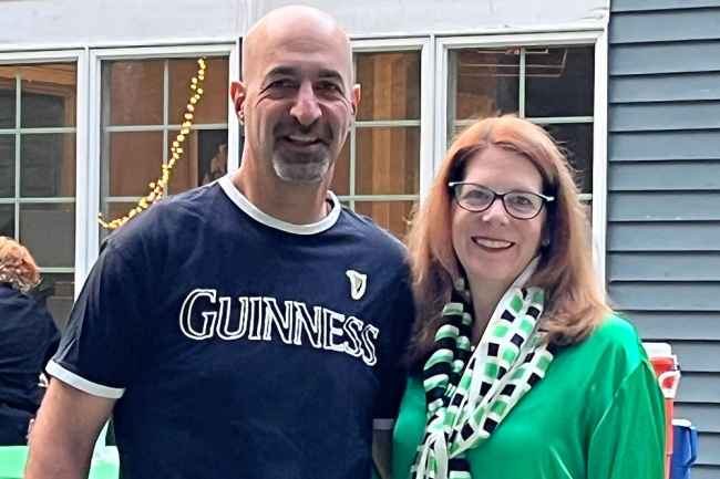 2 people pose at party outside a house