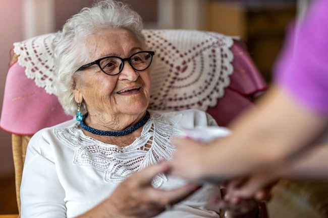 Older woman is given tea cup