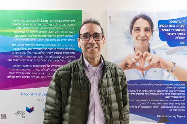 A man stands in front of a Deconstructing Stigma display