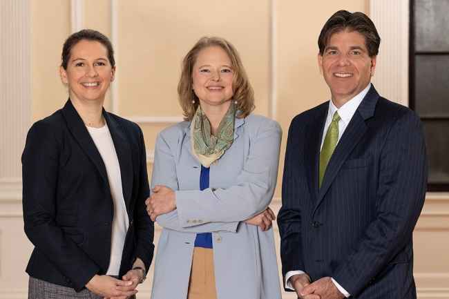 Three people standing and smiling at the camera