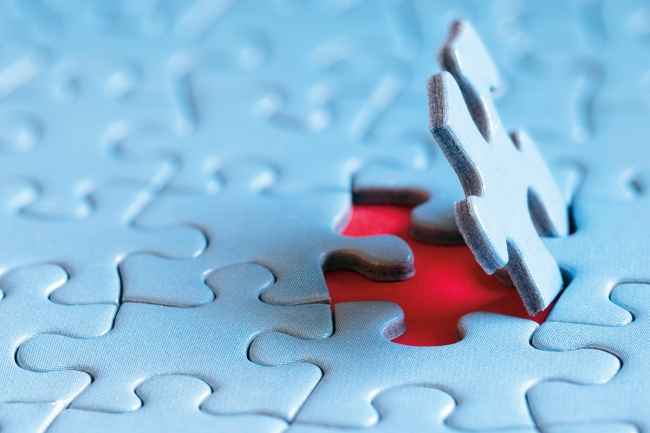 Puzzle piece fitting into place in a larger puzzle