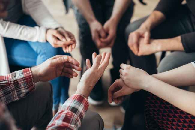 Hands of people in a circle during a group therapy