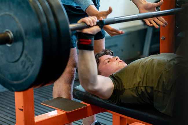 Teen lifting weights on a bench press