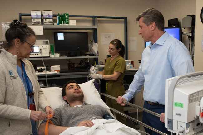 Doctor talks with patient in room with medical equipment