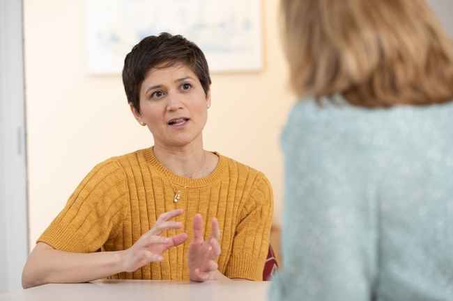 Woman in sweater talking to another woman