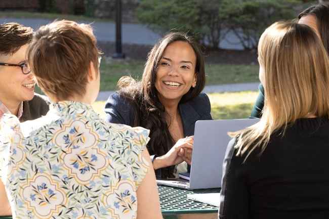 Staff work together at an outdoor picnic bench