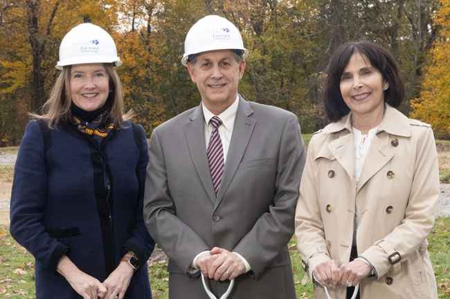 3 VIPs at a groundbreaking holding shovel handles, 2 with hard hats