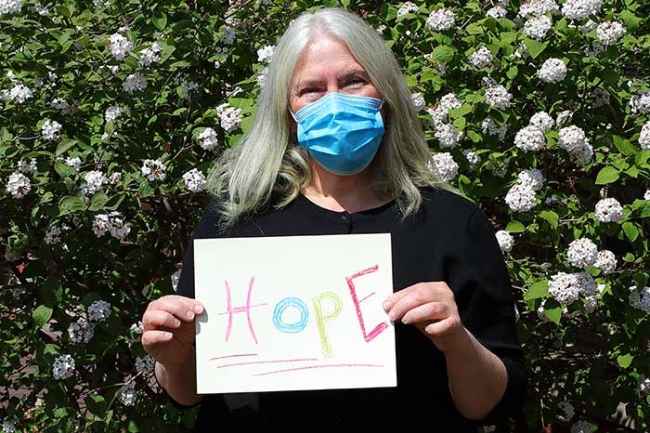 Rebecca Sanford holds up handwritten sign Hope