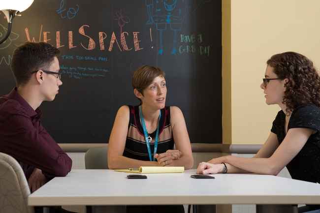 Clinician speaks with young adult patients in WellSpace