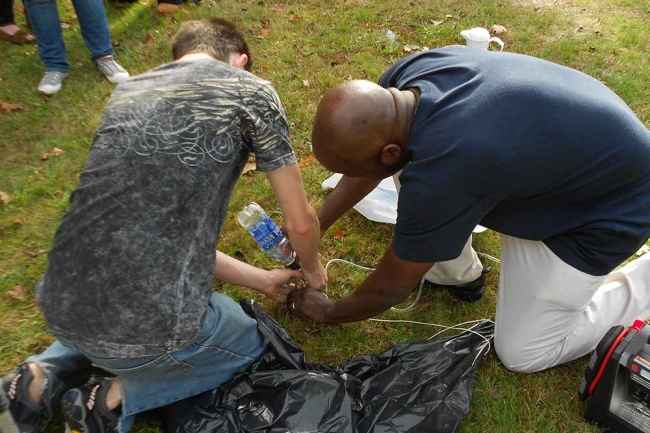 Two individuals with a water bottle outside