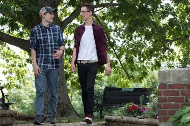 Two individuals walking and having a conversation outside