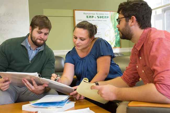 Group of clinical researchers look at binder of information