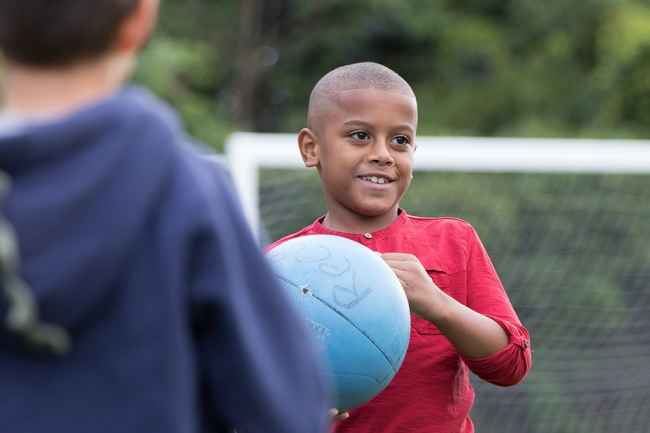Young kids playing with blue ball