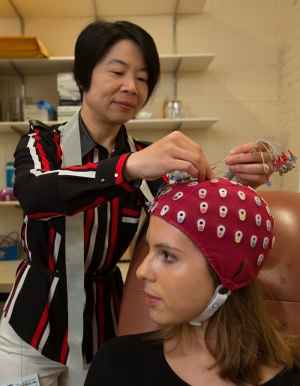 Researcher adjusts eeg cap on a study volunteer