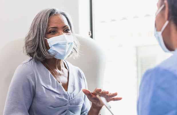 Woman in mask talking to a nurse