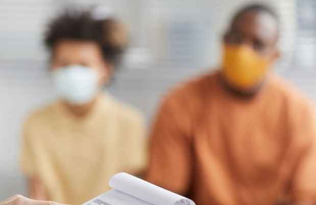 Nurse with clipboard and African American couple in background