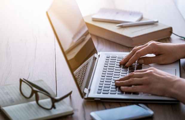 Hands typing on laptop