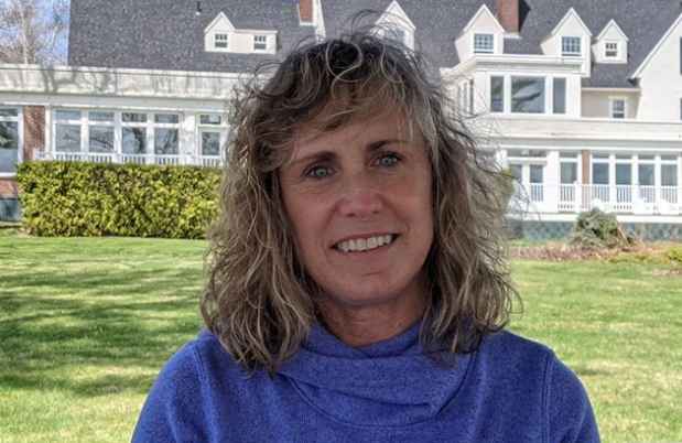 Woman outside large home on sunny day