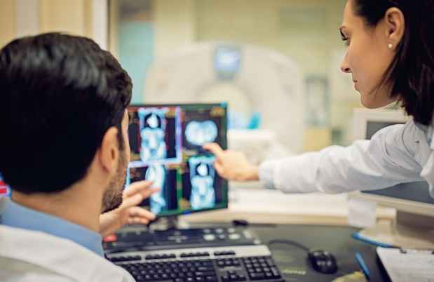 Researchers look at neuroimaging scans on computer screen