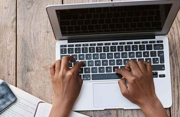 Hands typing on laptop