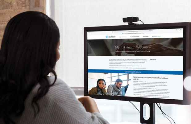 Woman looks at webpage on computer screen